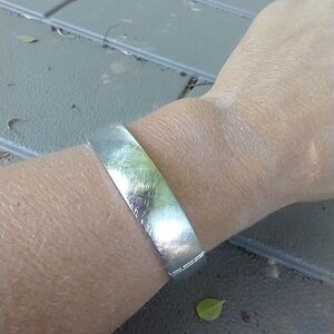 Women's silver tone hinged bracelet with chain.